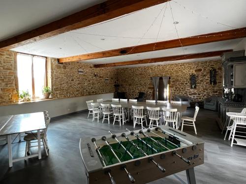 a room with a ping pong table and chairs at Domaine des Vignes d'Hôtes in Bagnols