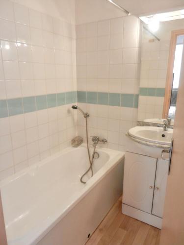 a bathroom with a tub and a sink at Appartement spacieux à Allevard - 68 m² avec vue montagne in Allevard