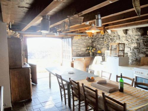 a kitchen and dining room with a table and chairs at Maison de charme dans le Parc des Volcans d'Auvergne avec terrasse in Lascelle