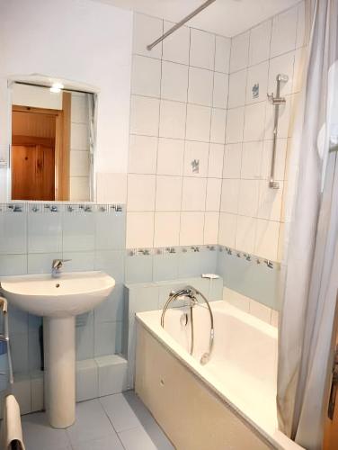 une salle de bain avec un lavabo et une baignoire et un lavabo dans l'établissement Appartement charmant à Plancher-les-Mines, cheminée, 90 m², à Plancher-les-Mines