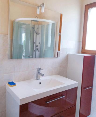 La salle de bains est pourvue d'un lavabo, d'un miroir et d'un réfrigérateur. dans l'établissement Chalet chaleureux à Darazac avec jardin de 60 m², à Darazac