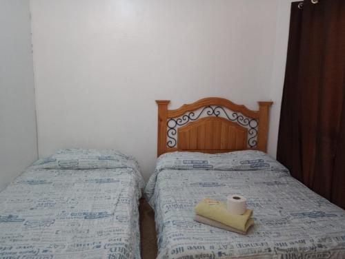 a bedroom with two twin beds with a candle on them at Hospedaje Rocha in Ica