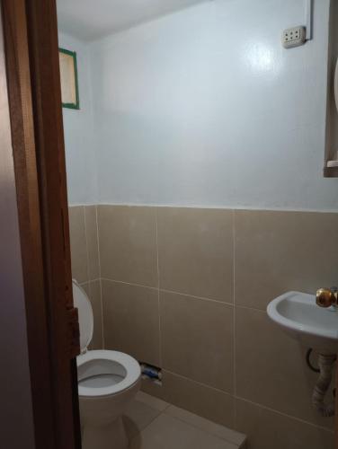 a bathroom with a toilet and a sink at Hospedaje Rocha in Ica