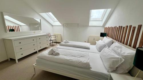 a white bedroom with a large bed and a mirror at 8 Personen I BBQ I Sunset in Herrsching am Ammersee