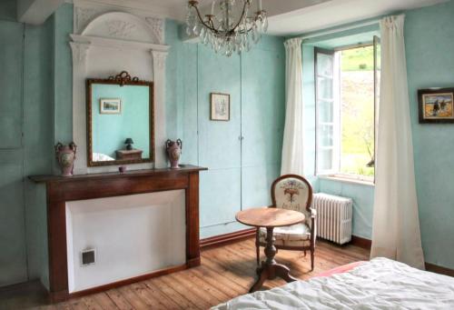 ein Schlafzimmer mit einem Kamin, einem Spiegel und einem Stuhl in der Unterkunft Maison familiale chaleureuse à Augirein avec grand jardin. in Augirein