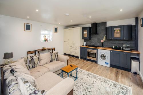 a living room with a couch and a kitchen at The Tucked-away Cottage in Huddersfield