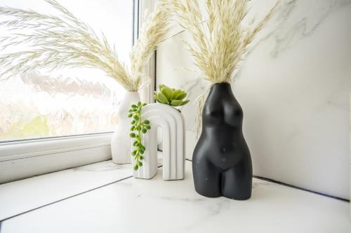 two black and white vases sitting on a window sill at The Tucked-away Cottage in Huddersfield
