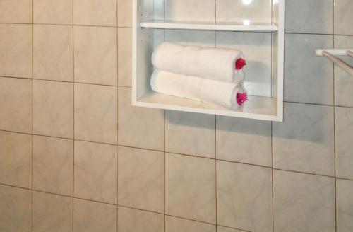 une pile de papier toilette sur une étagère dans une salle de bains dans l'établissement Appartement charmant à Sainte-Anne avec piscine partagée, 80 m², à Sainte-Anne