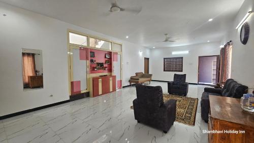 a living room with couches and chairs and a table at SHI's Kurunji 5BHK Villa in Pollachi in Pollāchi