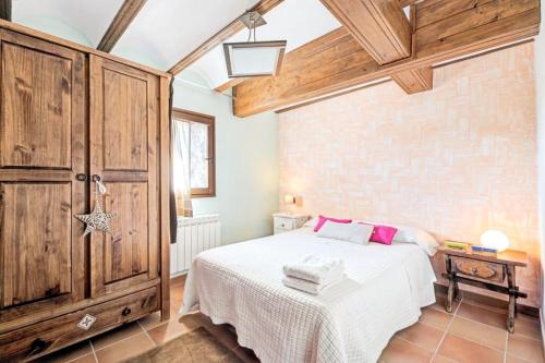 a bedroom with a white bed and wooden cabinets at Comfortable apartment in Ardanué - 55 m² - Parking available in Ardanué