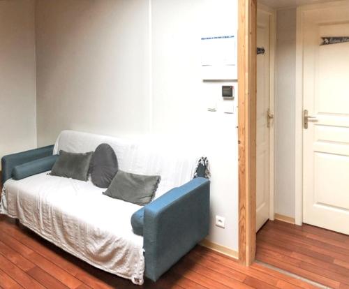 a blue couch sitting in a room next to a door at Maison ensoleillée à Saint-Pierre-d'Oléron avec piscine partagée in Saint-Pierre-dʼOléron