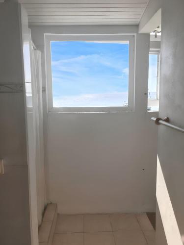 a window in a bathroom with a view of the ocean at Maison de charme à Saint-Pierre avec vue sur mer et montagne in Saint-Pierre