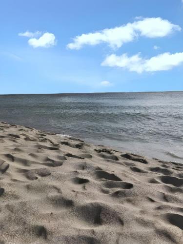 a beach with footprints in the sand and the water at Maison de charme à Saint-Pierre avec vue sur mer et montagne in Saint-Pierre
