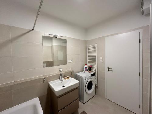 a bathroom with a washing machine and a sink at Nuppu1, free parking, self check-in in Trnávka