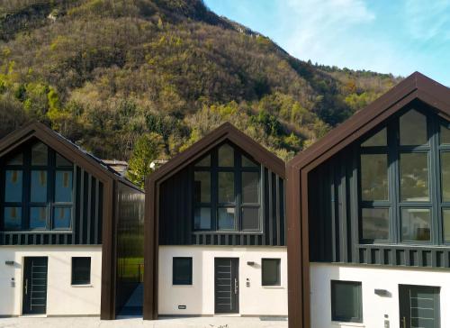 two houses in front of a mountain at Suite Alpina, profumo di legno e relax totale in Maso