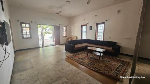a living room with a couch and a table at SHI's Kurunji 5BHK Villa in Pollachi in Pollāchi