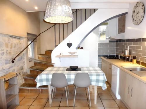 une cuisine avec une table et des chaises ainsi qu'un escalier dans l'établissement Maison cosy à Cardet avec piscine, à Cardet