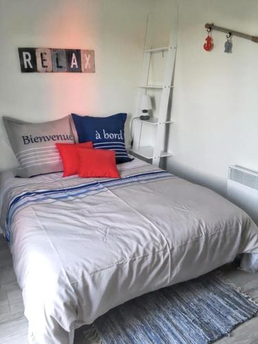 - une chambre avec un lit doté d'oreillers rouges et bleus dans l'établissement Charmante maison de campagne à La Bouillie avec jardinB, à La Bouillie