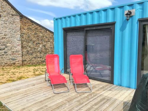two red chairs on the deck of a tiny house at Charmante maison de campagne à La Bouillie avec jardinB in La Bouillie