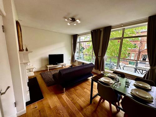 a living room with a couch and a table at Quiet residential area modern and cozy two bed apartment in Hampstead in London