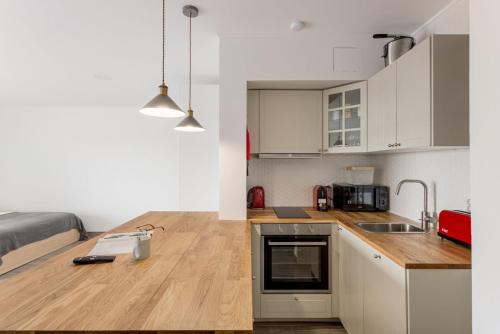 a kitchen with white cabinets and a wooden counter top at Estúdio 21 em Santa Bárbara de Nexe - Faro in Santa Bárbara de Nexe