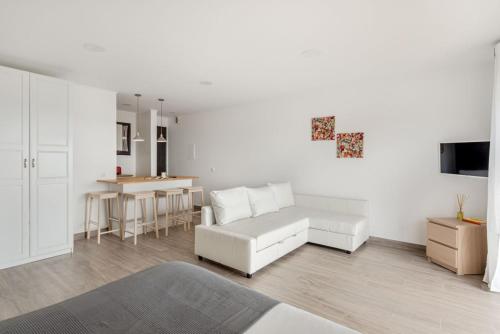 a living room with a white couch and a table at Estúdio 21 em Santa Bárbara de Nexe - Faro in Santa Bárbara de Nexe