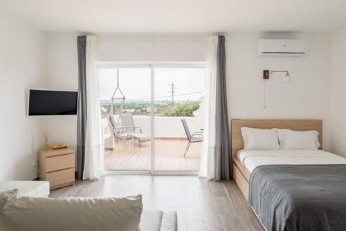 Un dormitorio con una cama y vista a un patio. en Estúdio 21 em Santa Bárbara de Nexe - Faro, en Santa Bárbara de Nexe
