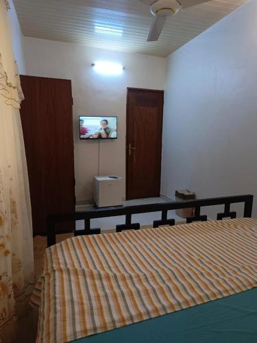 a bedroom with a bed and a tv on the wall at AMAL HoME in Ouagadougou