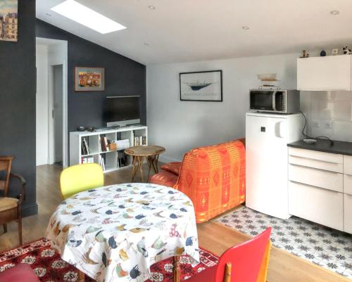 - une cuisine avec un réfrigérateur et une table dans la chambre dans l'établissement Appartement confortable au cœur du Pian-Médoc avec jardin, à Le Pian-Médoc