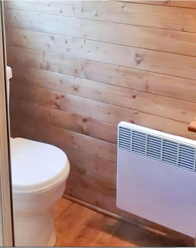 La salle de bains est pourvue de toilettes et d'un ventilateur. dans l'établissement Chalet confortable à Presles-et-Boves - 40 m² avec jardin, à Presles-et-Boves
