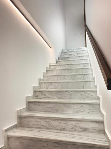 a staircase in a house with white walls and concrete stairs at Lithos House & Spa in Nafpaktos