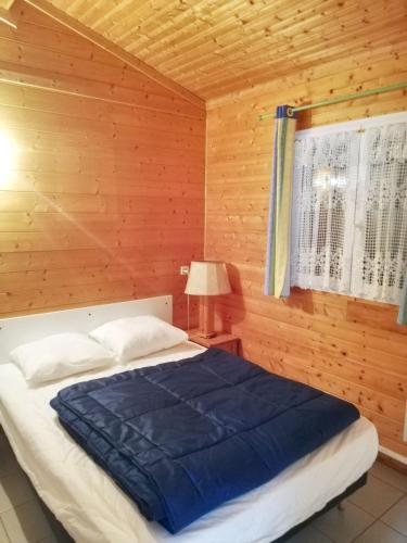 - une chambre avec un lit et un mur en bois dans l'établissement Chalet confortable à Presles-et-Boves - 40 m² avec jardin, à Presles-et-Boves