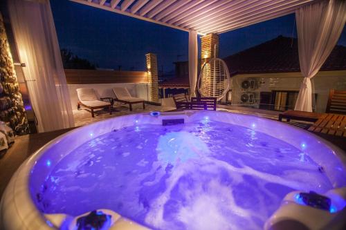 a large jacuzzi tub on a patio at night at Lithos House & Spa in Nafpaktos