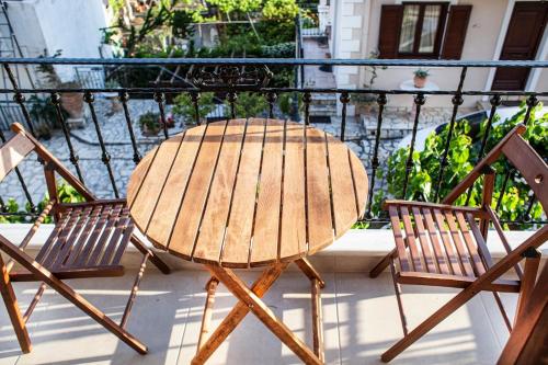 a wooden table and two chairs on a balcony at Lithos House & Spa in Nafpaktos