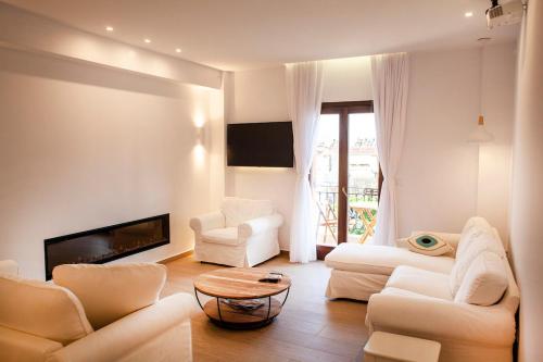 a living room with white furniture and a fireplace at Lithos House & Spa in Nafpaktos