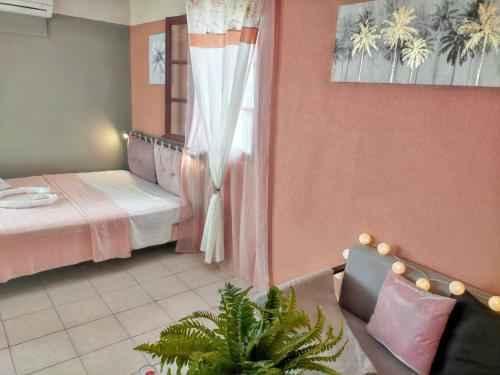 Habitación con 2 camas, sofá y ventana en Maison intime à Plessis Nogent avec piscine partagée, en Sainte-Rose
