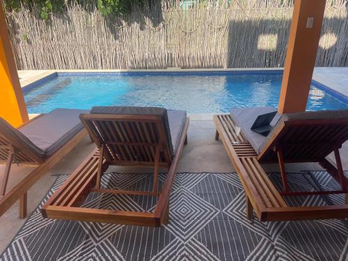 two lounge chairs sitting next to a swimming pool at The Bakers Villa Old Wharf Ltd in Treasure Beach