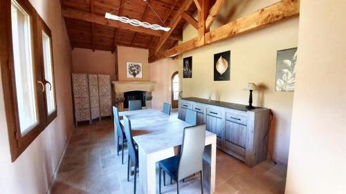 ein Esszimmer mit einem Holztisch und Stühlen in der Unterkunft Maison charmante au cœur de Puy-l'Évêque avec piscine partagée in Puy-lʼÉvêque