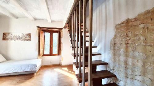 eine Treppe in einem Zimmer mit einer Steinmauer in der Unterkunft Maison charmante au cœur de Puy-l'Évêque avec piscine partagée in Puy-lʼÉvêque