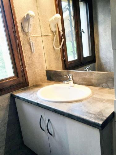 une salle de bain avec un lavabo et un miroir dans l'établissement Maison charmante au cœur de Puy-l'Évêque avec piscine partagée, à Puy-lʼÉvêque