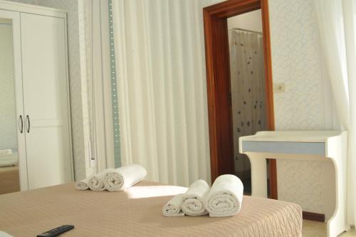 a bedroom with a bed with towels on it at Pensione Elena in Misano Adriatico