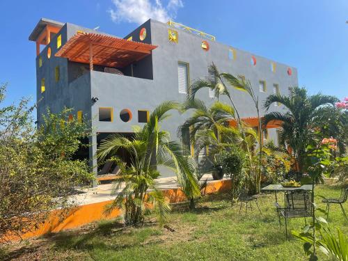 a building with palm trees in front of it at The Bakers Villa Old Wharf Ltd in Treasure Beach