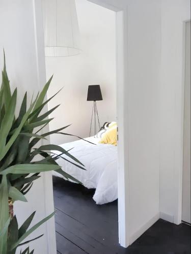 une chambre avec un lit et une plante en pot dans l'établissement Appartement moderne à Granville - 55 m² - Vue sur mer, à Granville