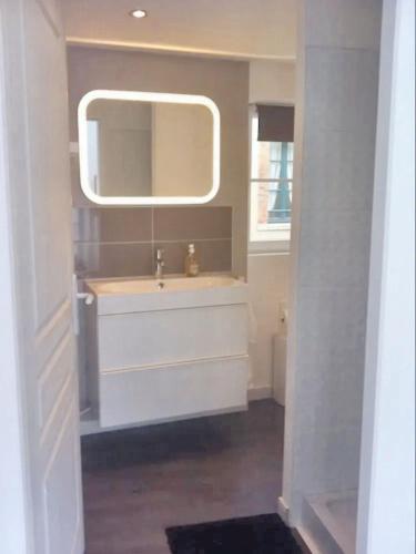 une salle de bain avec un lavabo et un miroir dans l'établissement Appartement moderne à Granville - 55 m² - Vue sur mer, à Granville