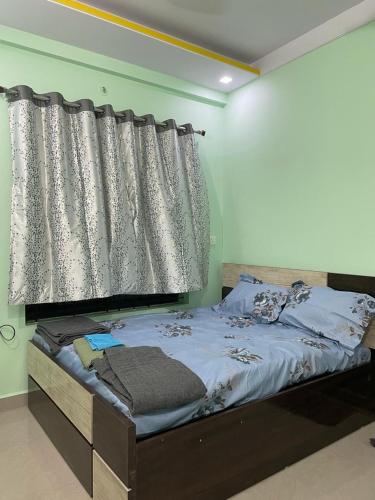 ナーグプルにあるSelf Check In 3BHK Houseの窓(カーテン付)が備わるドミトリールームのベッド1台分です。
