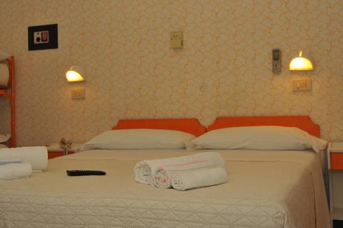 a bedroom with two beds with towels on them at Pensione Elena in Misano Adriatico