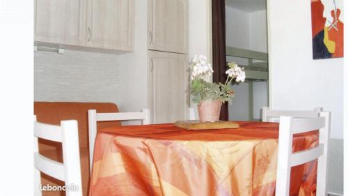 a table with a vase of flowers on it at Appartement cosy à Canet-en-Roussillon de 25 m² avec terrasse in Canet-en-Roussillon