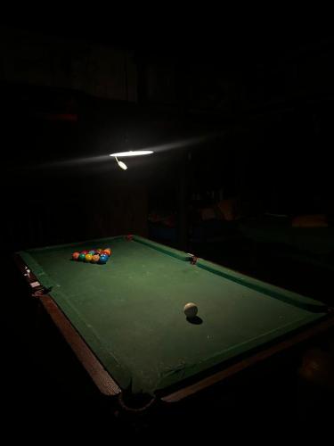 a pool table with balls on it in a dark room at Remo Hostel in Parati-Mirim