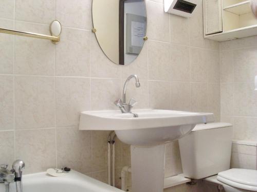 a bathroom with a sink and a toilet and a mirror at Appartement cosy à Canet-en-Roussillon de 25 m² avec terrasse in Canet-en-Roussillon
