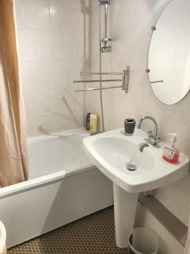 a white bathroom with a sink and a bath tub at Appartement cosy à Canet-en-Roussillon de 25 m² avec terrasse in Canet-en-Roussillon